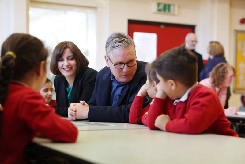 英國首相施凱爾（中）13日在大曼特斯特地區視察學童餐點期間接受媒體採訪表示，英國不支持美國對荷莫茲海峽實施封鎖。