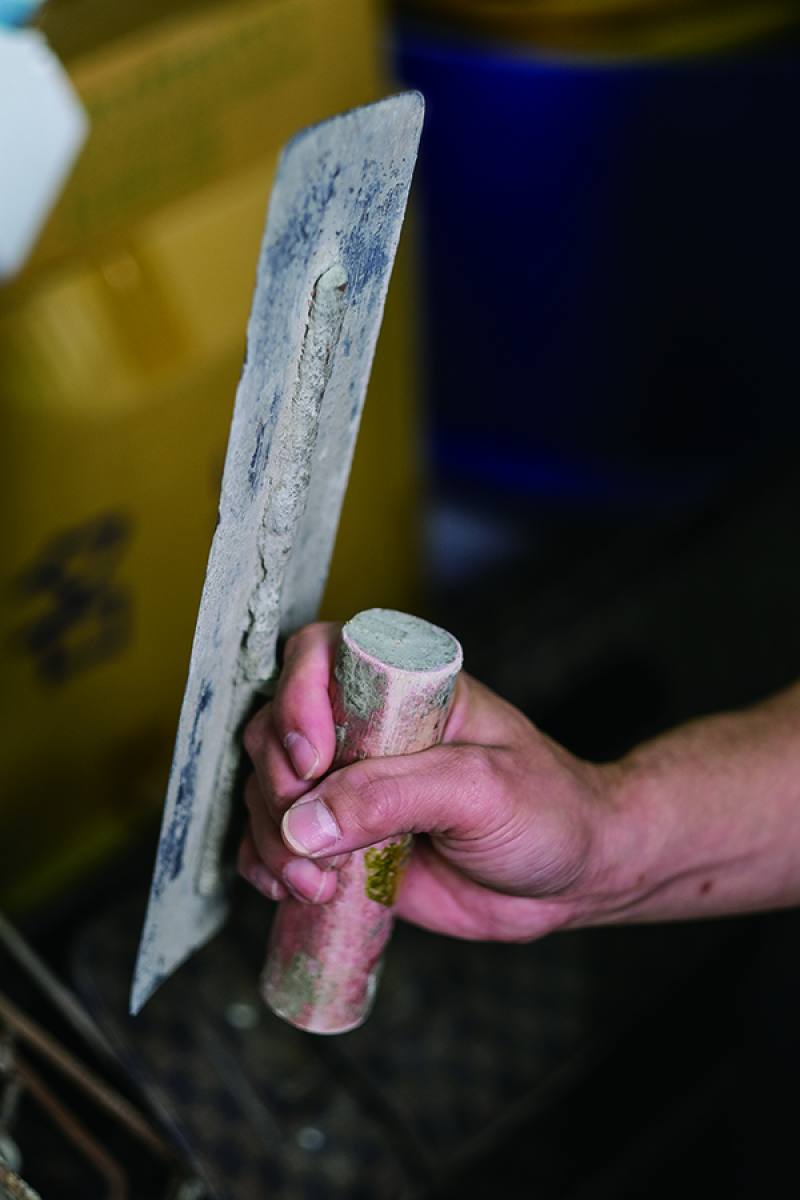 阿鴻入行超過30年，長時間握著圓鍬、鏝刀做工，縱使指關節早已變形，他也從不喊苦。Ah Hong has been wielding his trowel as a cement mason for over 30 years. Though his finger joints have long since become misshapen, he has no complaints.​​