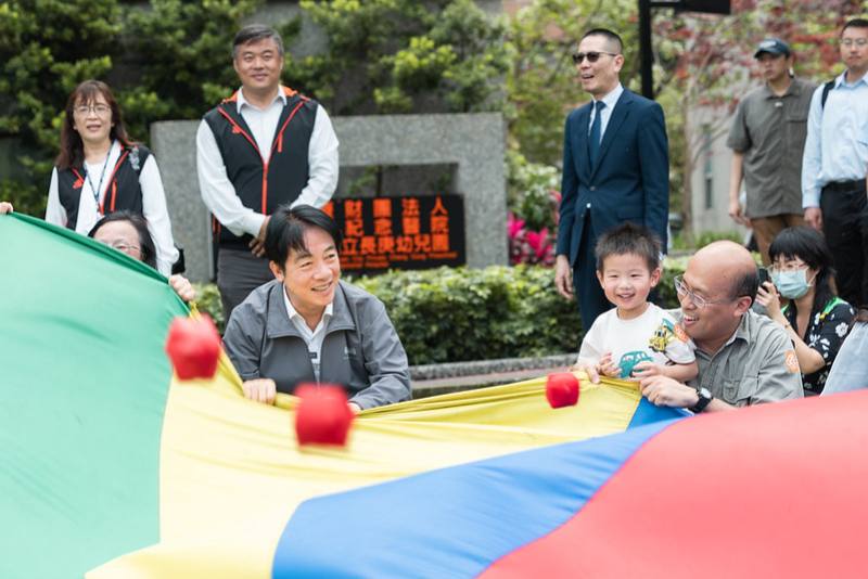 總統與小朋友一起玩氣球傘拋球遊戲，現場氣氛歡愉熱絡