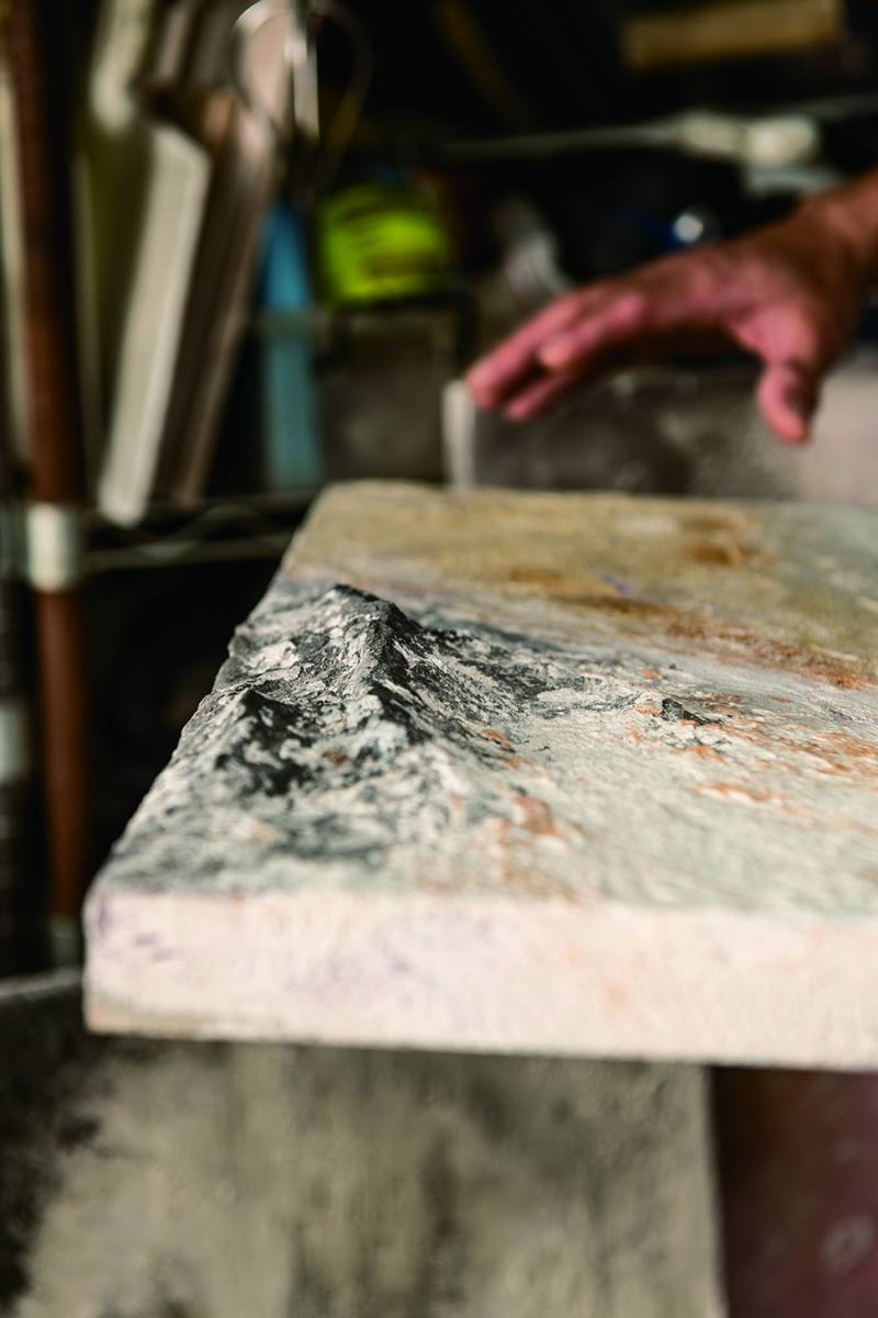 將水泥顏料堆疊，或用鏝刀或用手，細部雕刻，利用立體紋理造成的陰影差，營造湖邊礁岩的意象。By layering cement-based paint, using either his trowel or his hands, Ah Hong creates different levels of shading through precise 3D sculpting. The picture shows his depiction of a lake’s rocky shore.​​