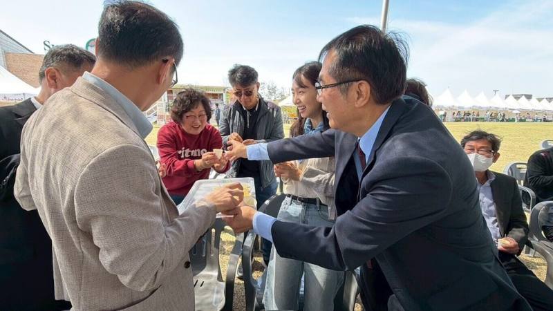 台南市長黃偉哲（右）率團訪韓，16日參加平澤花朵郊遊慶典，行銷台南鳳梨。（台南市政府提供）