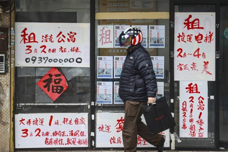 圖為民眾行經租屋廣告牆前。（中央社檔案照片）