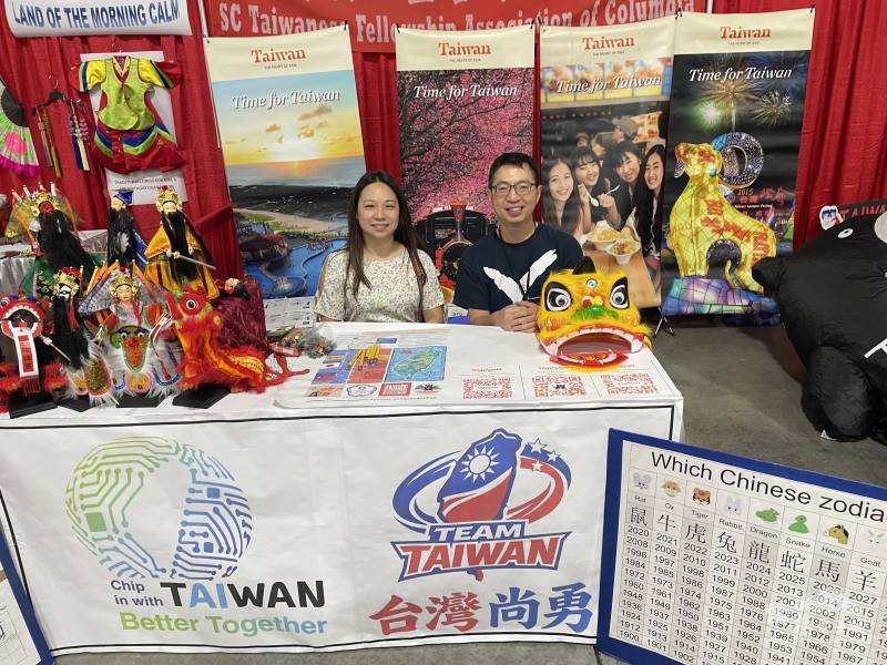 南卡哥倫比亞臺灣同鄉聯誼會於活動現場設置臺灣形象攤位，由陳浩鳴（右）與志工方思婷（左）熱情接待民眾推廣臺灣觀光與文化
