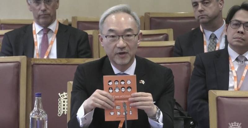 駐英國代表姚金祥20日應邀前往英國國會國家安全戰略聯席委員會，並出示出示有「小橘書」之稱的「台灣全民安全指引」。（圖取自英國國會網頁parliamentlive.tv）
