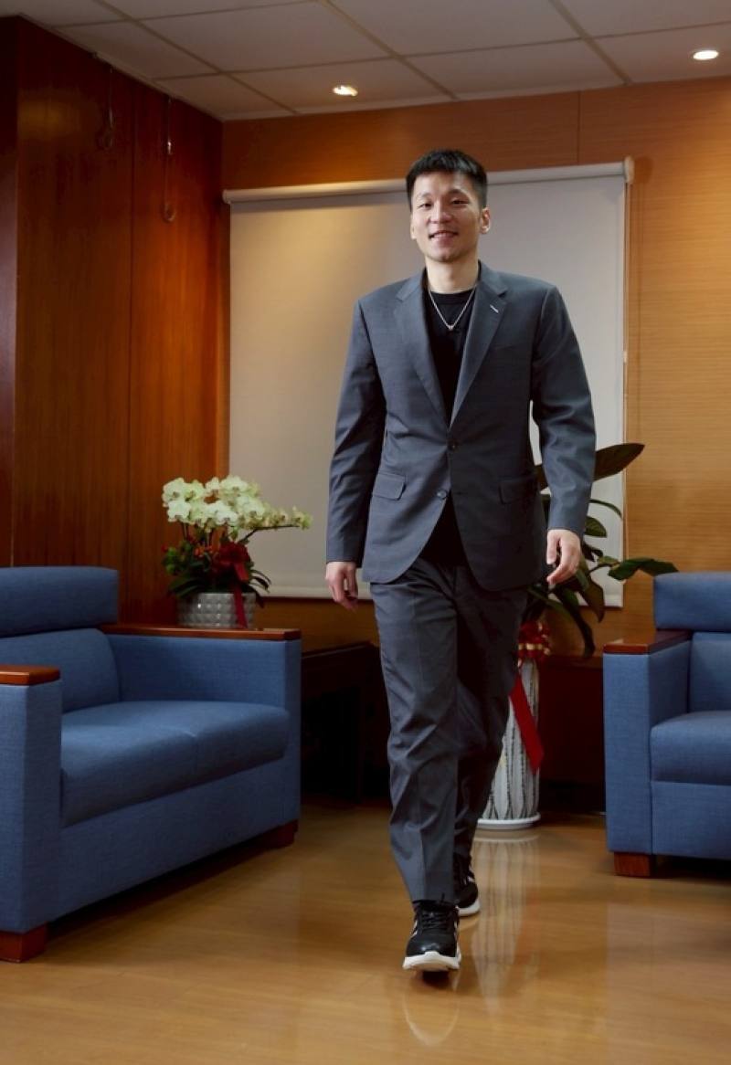 運動部長李洋（圖）是台灣運動部史上第一位部長，也是史上最年輕的部長。接受中央社專訪當天，李洋穿著深色西裝外套，裡面是簡單T恤，腳上則踩著一雙運動鞋，出賣了身體裡仍裝著運動員的靈魂。