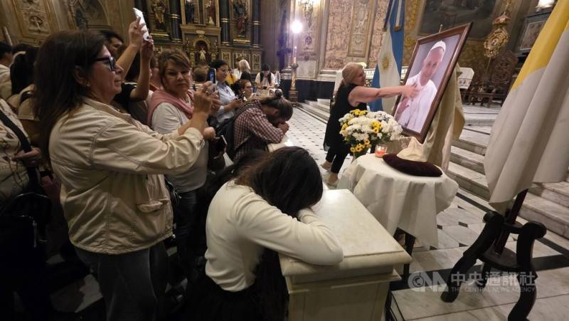 參與紀念已故教宗方濟各彌撒的阿根廷民眾，在教堂祭壇前的方濟各照片前靜默祈禱