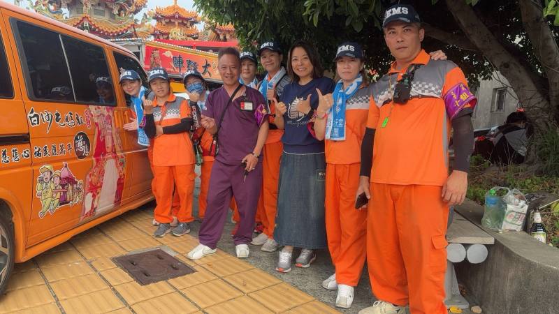王絹惠(中，藍色上衣)與團隊合影，並提及車輛上白沙屯媽祖影像，經過開光。(圖片由王絹惠提供)