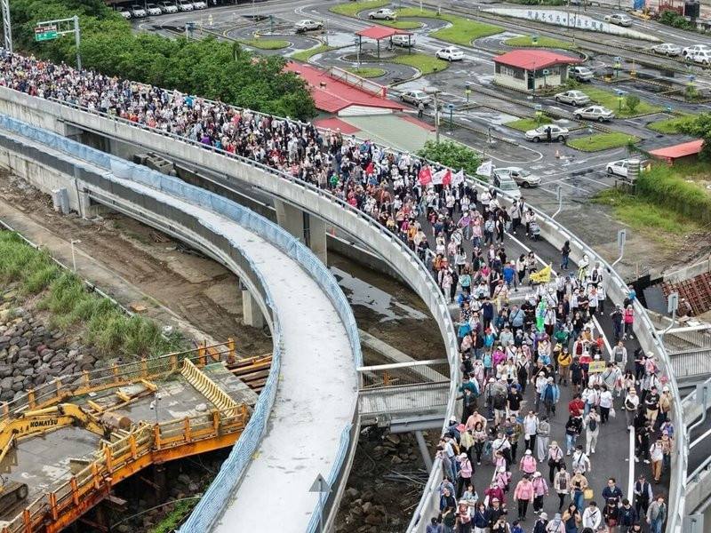 新北市府民政局25日舉辦淡江大橋通車前健行暖身活動，吸引綿延的人龍上橋，飽覽淡水河口景色。圖為空拍照片，參加健行人潮相當壯觀。（新北市府民政局提供）