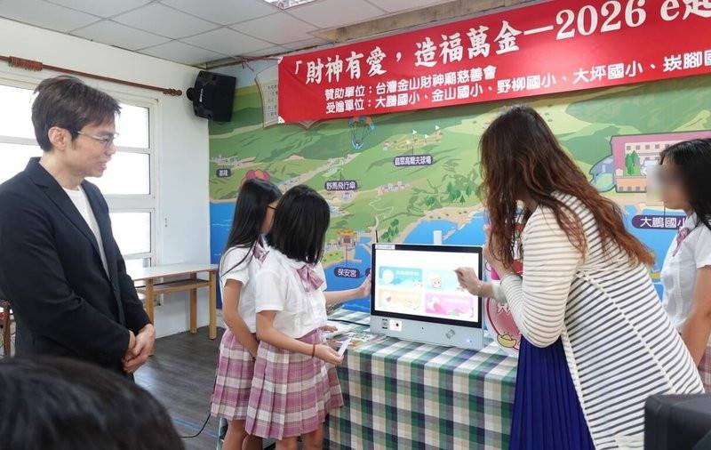 新北市萬里區大鵬國小表示，金山財神廟慈善會23日捐助新台幣70萬元，協助北海岸偏鄉國中小學，建置人工智慧（AI）閱讀系統，提升閱讀能量。圖為現場安排展示智慧閱讀系統實機，體驗AI閱讀的便利與創新。（新北市大鵬國小提供）