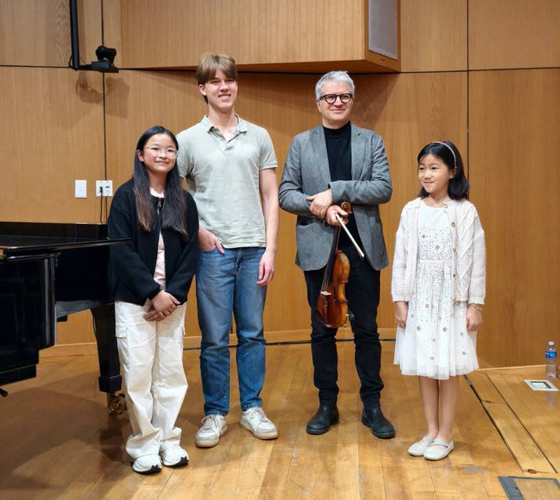 年僅10歲的王晞恩（右1）與13歲的楊雋婷（左1），在僅有3個名額的南非大學小提琴大師班中通過甄選，兩人在以大學生為主的選拔中入選，引發當地音樂界關注。該大師班由義大利小提琴家弗朗切斯科．多拉齊奧（右2）主持。（王晞恩母親蔣鈺提供）