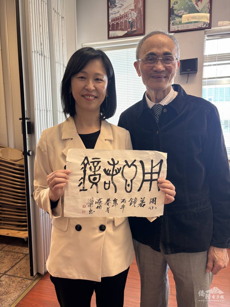 駐溫哥華辦事處僑務組長郭淑貞(左)獲陳柏梁(右)贈與「用心若鏡」的書法。(張伶銖攝)