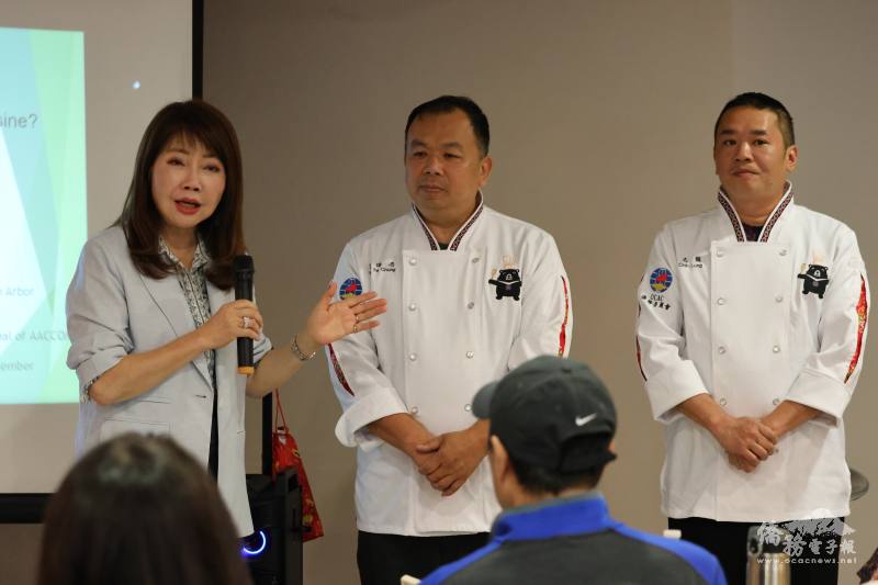 密西根僑務委員盧蔓菁向僑胞介紹此次遠道而來的兩位客家料理主廚范德忠(中)與李志龍(右)師傅