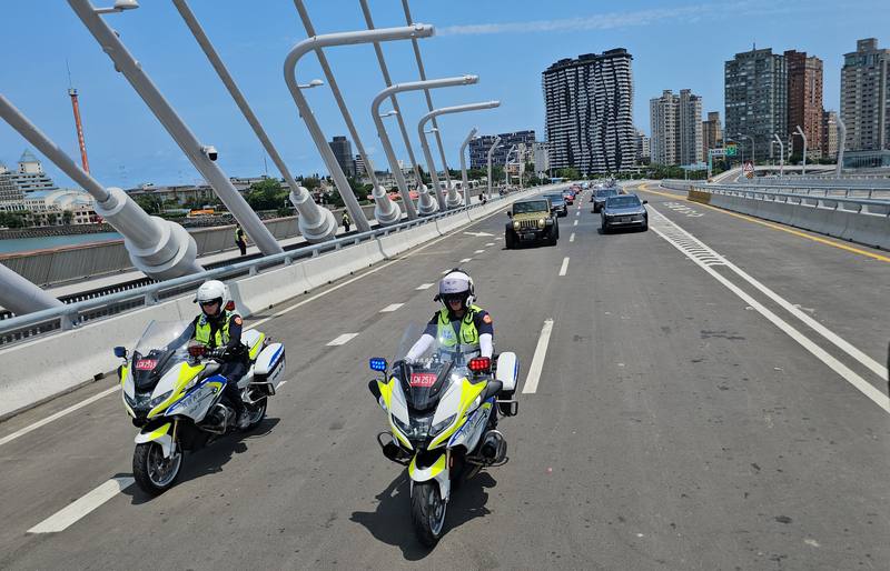 在警車引導下，交通部長陳世凱開車（綠色吉普車）帶領車隊開上淡江大橋。