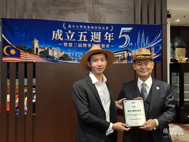 洪宇哲（左）致贈紀念品予義守大學校友總會副總會長洪國興（右），象徵海內外校友情誼緊密連結