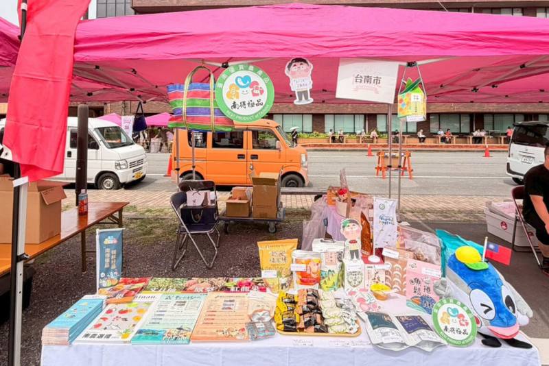 台南市政府農業局前往日本拓銷農漁產品，14日在靜岡縣東伊豆町舉辦的「伊豆稻取KINME馬拉松活動」設置攤位，展出魚鬆捲心酥、越光糙米棒等多種加工產品。（台南市政府提供）