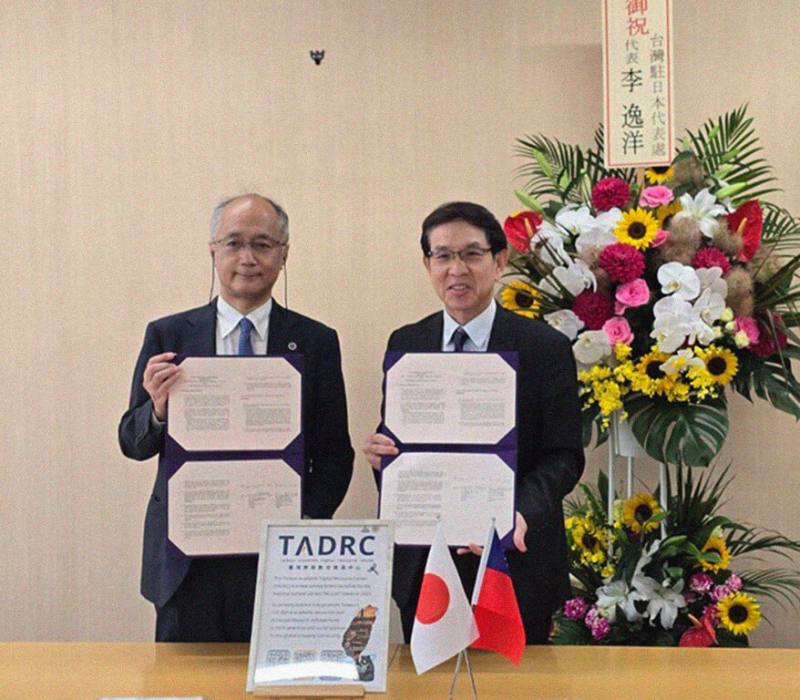 國家圖書館與日本筑波大學圖書館共同成立日本首座「台灣學術數位資源中心」，17日在筑波大學完成簽署與啟用。筑波大學副校長暨圖書館館長加藤和彥（左）與國圖代理館長翁誌聰（右）簽約並合影。（國家圖書館提供）