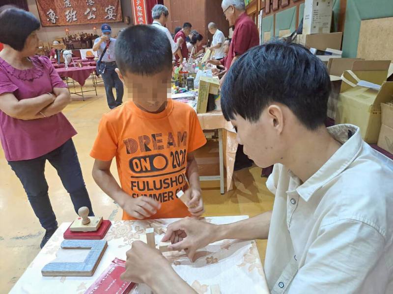 彰化大葉大學學生組成志工隊參加鹿港魯班公宴活動，擔任魯班鎖體驗教學志工，藉由拆解與組裝魯班鎖的過程，引導小朋友了解傳統榫卯工藝與在地文化。（大葉大學提供）