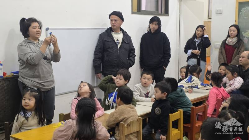 僑務委員會海外民俗文化種子教師胡儒儀(左1)向阿根廷僑聯中文學校幼兒部親子示範彩虹平安粽的製作方式，並透過華語文問答引導學生認識材料與練習數數