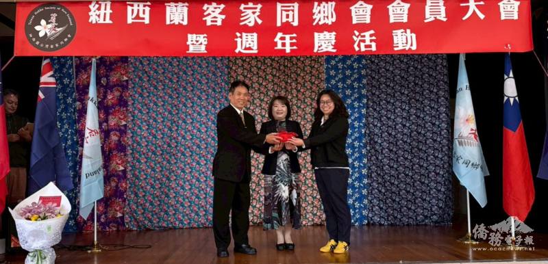 駐奧克蘭辦事處處長陳詠韶(中)監交，紐西蘭客家同鄉會理事長江文通(左)繳出亮眼成績單功成卸任交棒給張心容(右)，順利完成紐西蘭客家同鄉會的世代交替
