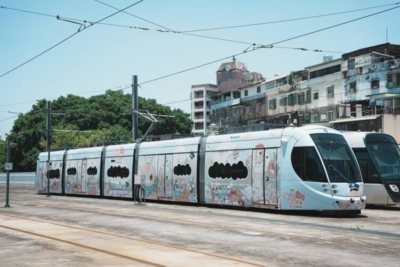 高雄捷運股份有限公司與橘子集團旗下原創內容平台MOJOIN聯名推輕軌彩繪列車，6月22日啟航到9月30日。蜜柑站長躍上車廂內、外，讓乘客沉浸式感受作品溫暖療癒氛圍。（高捷公司提供）