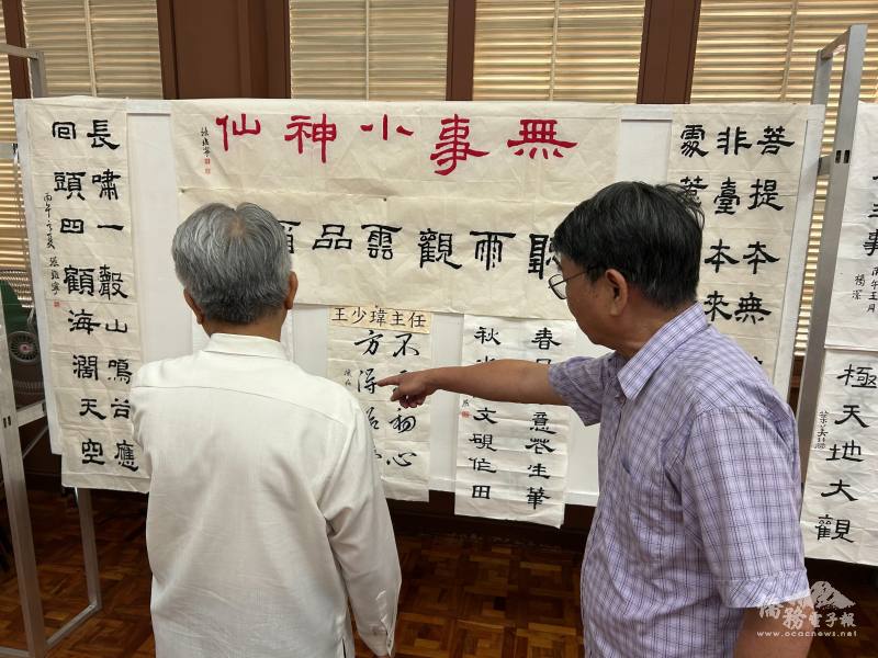 與會貴賓參觀書法班成果展，教師詹坤艋介紹學員書法作品