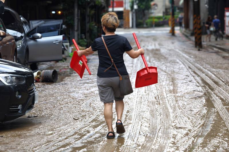 圖為25日內湖區內湖路3段低窪地區積水退去後，民眾購買掃除器具著手整理家園。