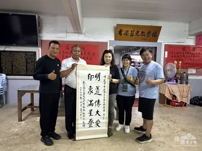 泰北大同中學校長張明光（左2）、榮譽校長田景燦（左1）向明道志工團團長許慧琪（右3）、領隊古鎧榮（右2）、帶隊老師陳亦帆（右1）致贈墨寶