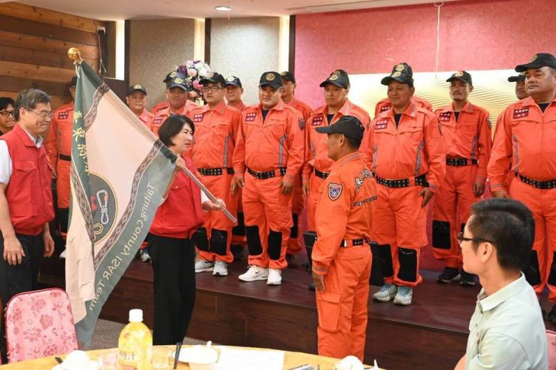 台東縣消防局原民特搜隊30日正式成軍，縣長饒慶鈴（前左2）親自授旗，宣告35名原鄉勇士將肩負起原民鄉第一應變任務。（台東縣政府提供）