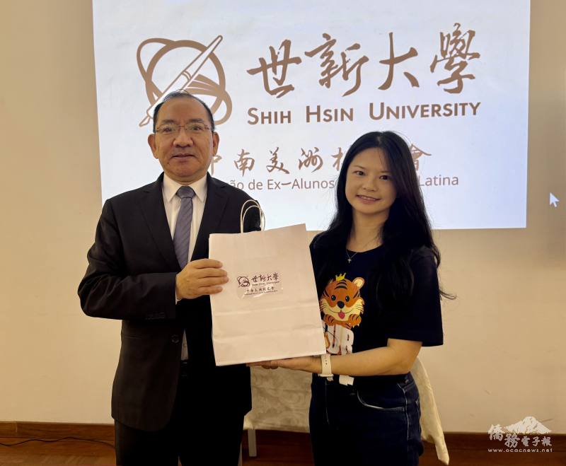 謝如欣（右）代表世新大學致贈禮品給聖保羅文教中心主任尤正才（左）