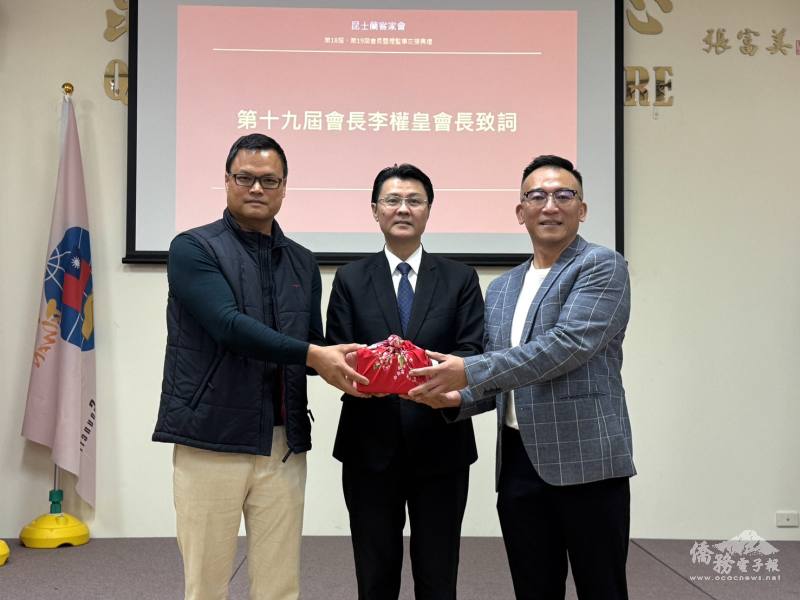 澳洲昆士蘭客家會卸任會長鄭仲哲(右)交棒予新任會長李權皇(左)，由駐布里斯本辦事處處長范厚祿(中)見證監交