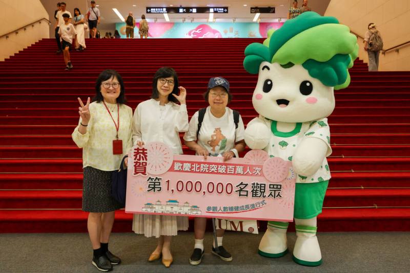 故宮博物院北院2026年參觀人次在8日突破百萬，故宮副院長余佩瑾（左2）與故宮吉祥物「小翠」一同與第100萬人次幸運觀眾合影留念。（故宮提供）
