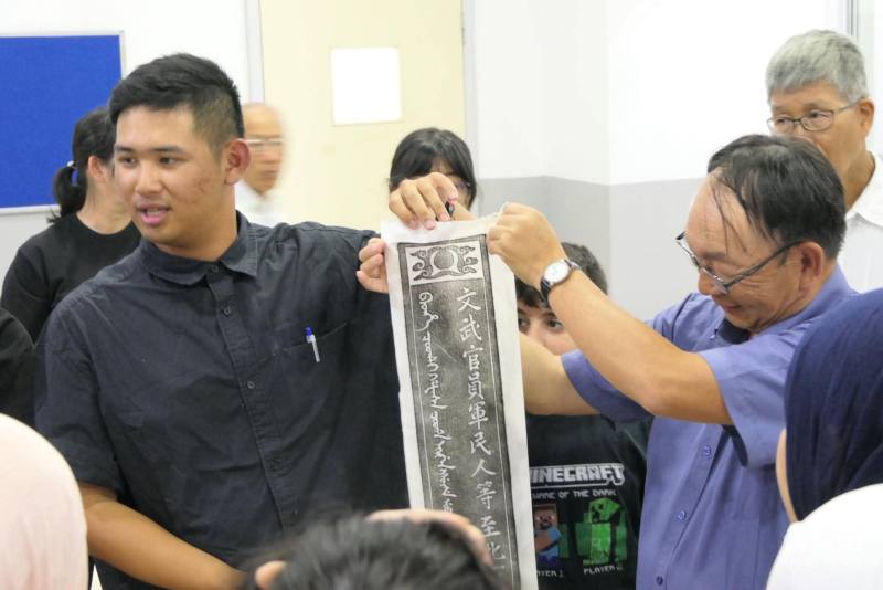老師曾國棟及學生曾楷錡帶領滿納海學生體驗拓碑文化，並展示完成的作品，透過實作促進雙方文化交流。（右一為曾國棟，左一為曾楷錡）