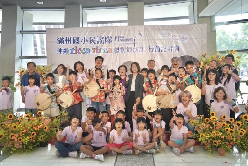 屏東縣滿州國小民謠隊受邀參加日本沖繩國際兒童青少年藝術節，17日在屏東演藝廳舉辦行前記者會，縣長周春米（中，西裝外套）到場為孩子加油打氣。（屏東縣政府文化處提供）