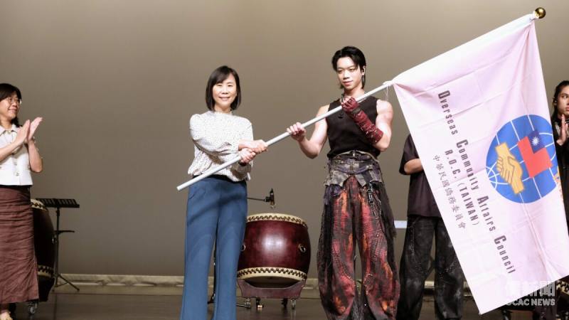 僑委會主任秘書榮幼娥(左)授旗予訪問團團長謝家茗(右)