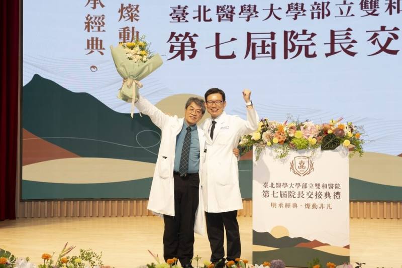 衛福部雙和醫院28日舉行院長交接典禮，卸任院長李明哲（左）與新任院長劉燦宏（右）在台上合影，彼此送上感謝與祝福。（雙和醫院提供）