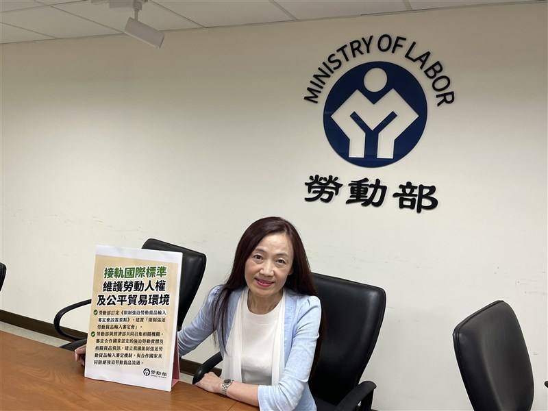 Ministry of Labor official Huang Chi-ya holds a placard at a news briefing in Taipei on Thursday.