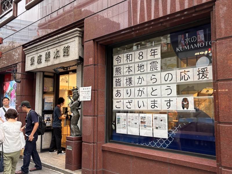 日本熊本地震發生後，位於東京銀座的熊本縣物產館「銀座熊本館」吸引大批民眾前往購買熊本特產，以實際消費支持災區。店面朝向大馬路的櫥窗上貼著「令和8年熊本地震，感謝大家的支持」的文字，最後是熊本縣吉祥物「熊本熊」低頭致謝的圖樣，向各界表達感謝之意。