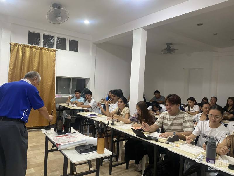 華語教師張謀帶領學員揮毫書寫春聯，透過書法體驗認識漢字與傳統文化。