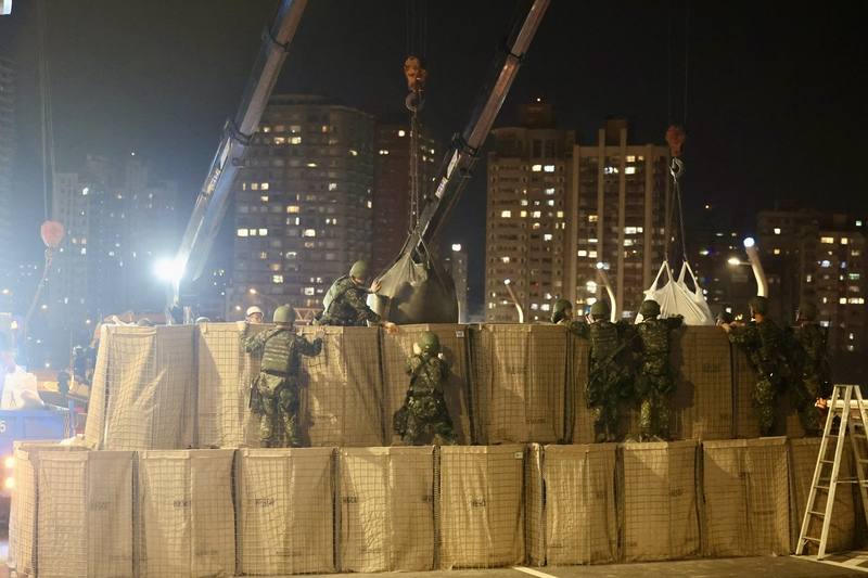 Military personnel set up a blockade using concrete blocks, steel hedgehogs, barbed wire and U.S.-made HESCO bastions on the Danjiang Bridge in New Taipei on late Thursday.