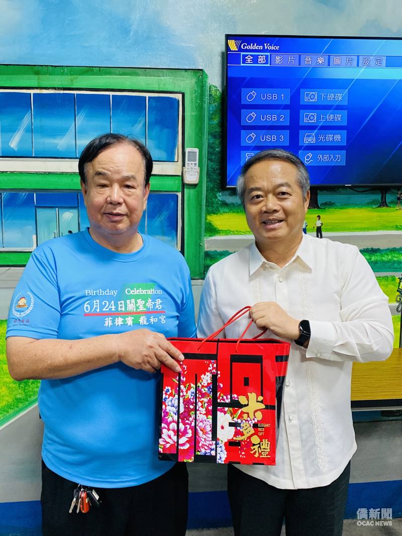 周民淦(右)致贈禮品予龍和宮主任委員暨僑務委員謝儀和(左)。