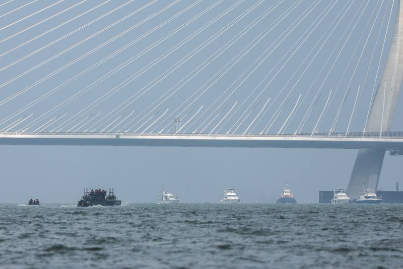 Military personnel ride in an M3 amphibious bridging vehicle and assault boats near the Danjiang Bridge during the third day of the Han Kuang military exercises in New Taipei on Friday.
