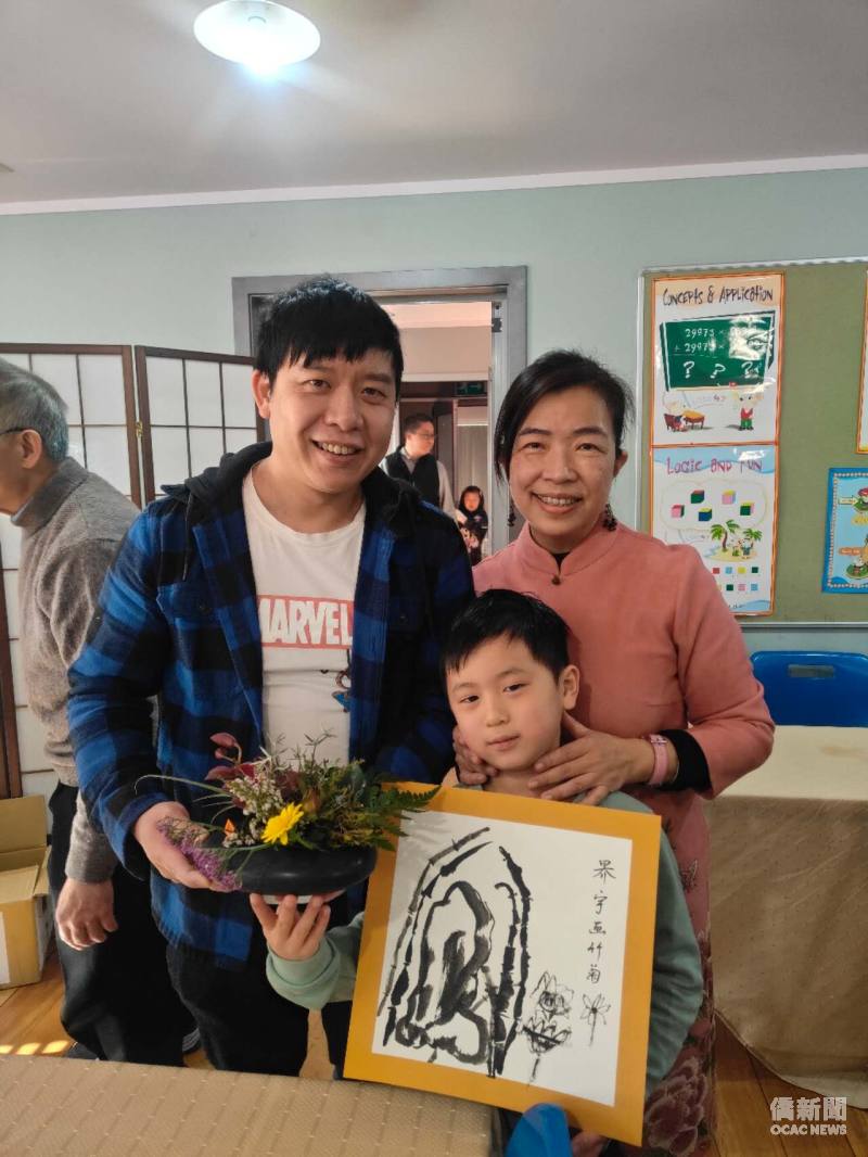 Michael's son serves tea to his family during a holiday programme at Chi Yuan Education Centre, alongside his Chinese ink painting.(right:Teacher Sheryl Tseng)