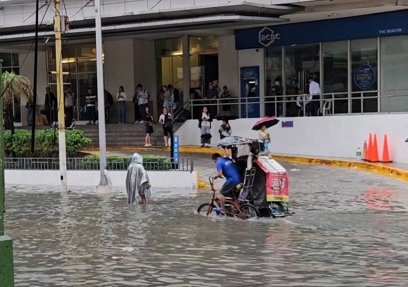 菲律賓正值雨季，大馬尼拉地區多處因豪雨而淹水，鉤端螺旋體病感染風險隨之升高。圖為在馬卡蒂市（Makati）民眾騎三輪車涉水而過。