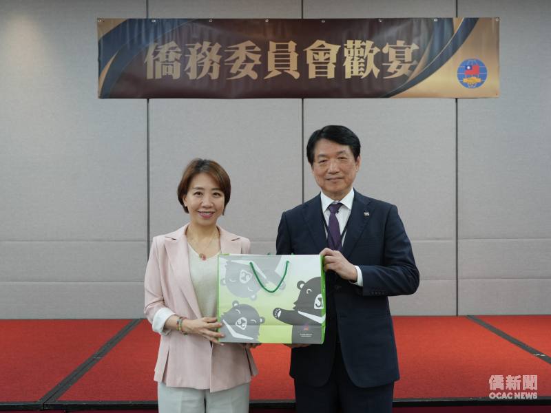 李姸慧（左）代表僑委會與頼本勉（右）代表訪團互贈紀念品。