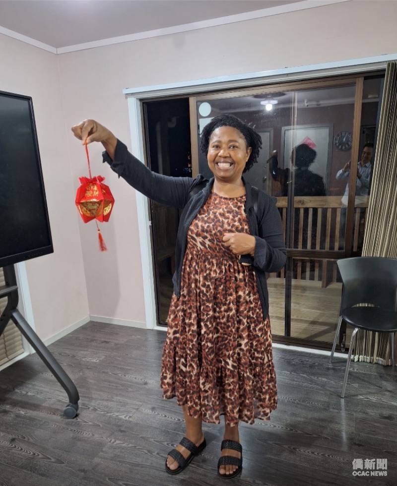 Natalia happily completing a lantern made from red envelopes.