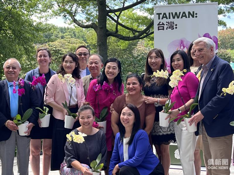 (立者左起)皇后區慶籌會主委王金智、Nily Rozic、紐約文教中心主任王怡如、吳達義(左5)、黃敏儀、Evie Hantzopoulos、黃百齡、David Weprin (右1)等貴賓手捧蘭花開心合影
