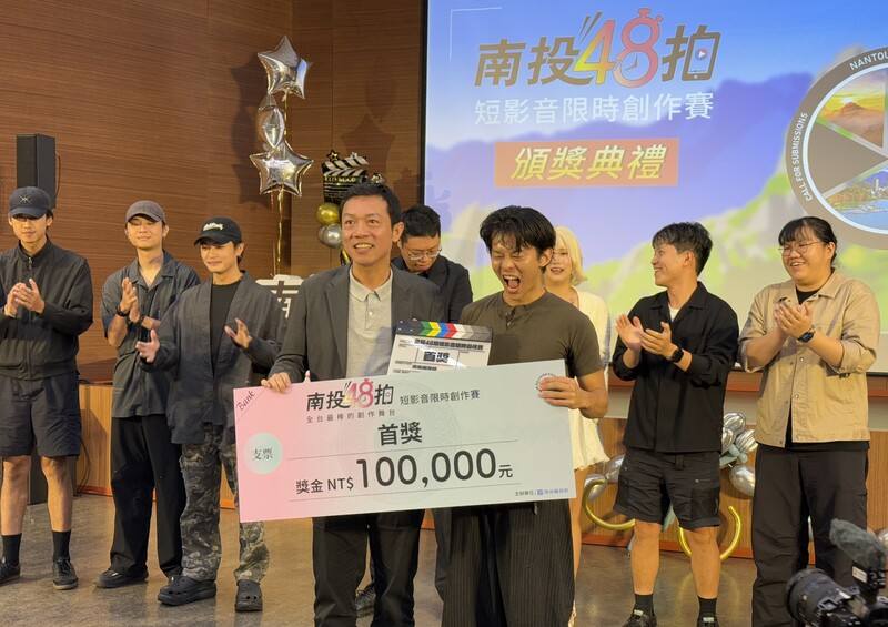 南投縣政府主辦「南投48拍」短影音限時創作賽，27日頒獎，新聞及行政處長蔡明志（前左）頒發首獎新台幣10萬元獎金給以水里鄉、偏鄉醫療為主題的創作者翁于翔（前右）。
