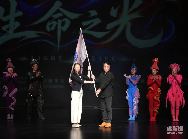 僑務委員會僑教處副處長陳柏琴（左）授旗予115年雙十國慶文化訪問團團長、舞鈴劇場創辦人暨藝術總監劉樂群（右）。