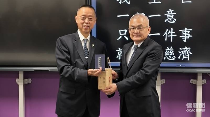 黃思賢致贈感謝禮予慈濟英國負責人朱建隆。