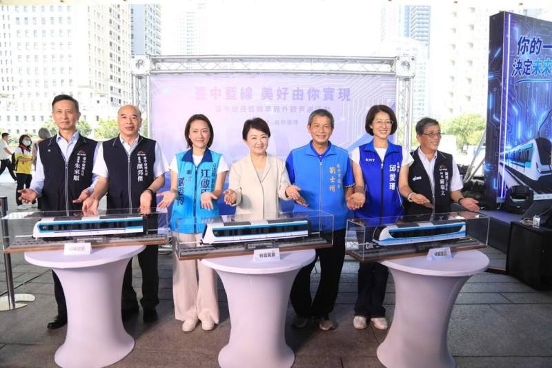 台中市捷工局7日舉行「台中捷運藍線電聯車外觀票選活動」記者會，台中市長盧秀燕（中）宣布票選活動將於10日開跑，共有3款車廂造型邀民眾投票。（台中市政府提供）
